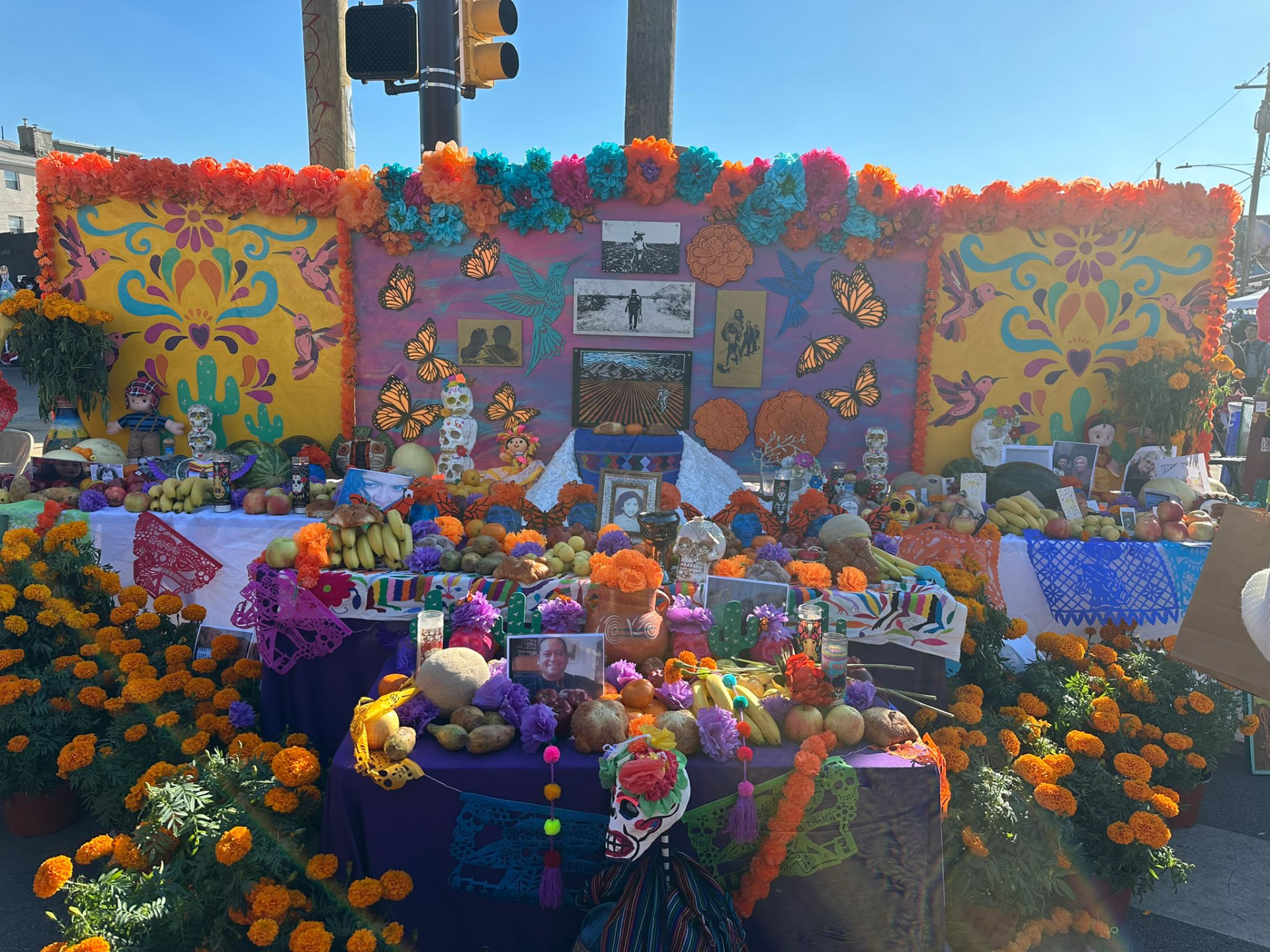 Community altar surrounded by marigolds, fruit and family photographs